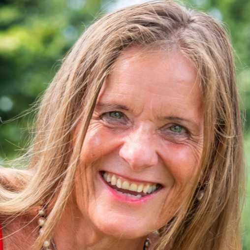 Porträt von Margit Fröhlich mit langem hellbraunem Haar und freundlichem Lächeln