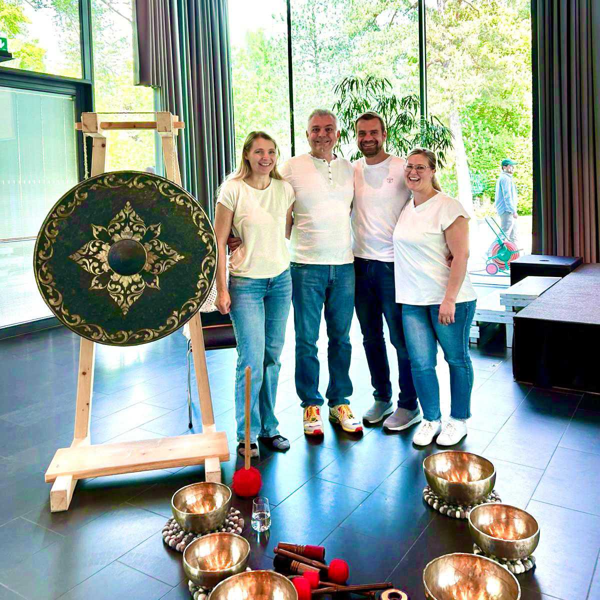 Team des großen Klangbads mit Gong, Klangschalen und Schlägeln in einem hellen Veranstaltungsraum